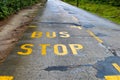 Road signals bus stop yellow word written on asphalt