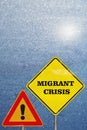 A road signs Attention and Migrant Crisis on blue