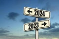 Road signs indicate the path to the new year 2024 and the old year 2023 on a blue sky, creative idea. Choose a new road, concept. Royalty Free Stock Photo