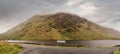 Road signs in Irish and English language Leenaun and Louisburgh by a road. Beautiful scenery in the background. Mountains and low