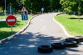 Road signs - no entry, reversal, turn right. Rubber tires on the road. Autodrome in the park.