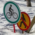 Road signs: permitting the passage of cyclist and prohibiting the movement of  pedestrian against the background of snow Royalty Free Stock Photo