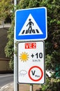 Road signs in Portuguese island Madeira. Blue zebra crossing sign. White speed limit sign. The speed restriction is dependent on