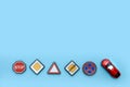 road signs and toy car on blue background with copy space Royalty Free Stock Photo
