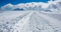 Road for snow-grooming machine, or snowcat, on the surface of the glacier in high mountains.