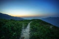 Road on spine and the top of the mountains covered with greenery with gentle valleys at dawn