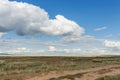 Road in the steppe. Clouds float across the sky over meadows. Tyva. Steppe. Sunny summer day Royalty Free Stock Photo