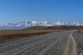 Road steppe mountain snow sky Royalty Free Stock Photo