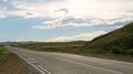 Road in steppe under a blue sky with white clouds Sayan mountains Siberia Russia Royalty Free Stock Photo