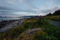 Road near shore of the lake with view to mountains in the Norway at summer sunset Royalty Free Stock Photo