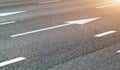 Road straight forward arrow direction sign on sunny asphalt road ground. pointing white arrow road sign painted on black asphalt Royalty Free Stock Photo