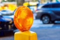 In a road street under reconstruction, orange construction warning lights are displayed on barricade