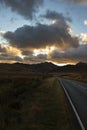 A4086 road, at sunset, heading towards the Llanberis Pass with mount Snowdon in the distance.