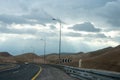 Road surrounded by hills under the sunlight and a cloudy sky at daytime Royalty Free Stock Photo