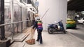 Road sweeper or Street cleaners ,woman carry broom cleaning the street in bangkok city Royalty Free Stock Photo