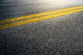 Double yellow lines on asphalt street roadway surface texture background. Royalty Free Stock Photo