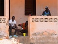 Unidentified local three men locate on the porch in a village i