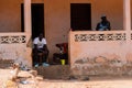 Unidentified local three men locate on the porch in a village i