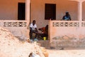 Unidentified local three men locate on the porch in a village i