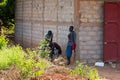 Unidentified local three men stand behind the shed in a village