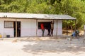 Unidentified local three men stand near the house in a village