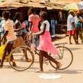 Unidentified local woman pulls a bicycle in a village in Guinea