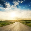 Road to horizon in sunset. Low clouds with sun Royalty Free Stock Photo