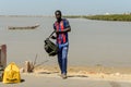 Unidentified Senegalese man with backpack waits for a taxi arri