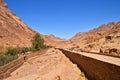 Road to the monastery of St. Catherine, pilgrims, tourists go to the monastery, olive trees, buildings, mountains, blue sky