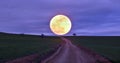 Road to the moon, the moon rises beyond the fields