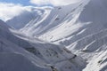 The road to the mountain gorge in winter. Snow-covered slopes of the Caucasus Mountains Royalty Free Stock Photo