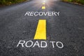 Road to recovery word on asphalt road surface with marking lines