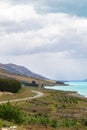 Road to the Southern Alps. Along the shore of the turquoise lake Pukaki. New Zealand Royalty Free Stock Photo