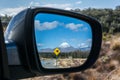Road to Tongariro National Park with Kiwi sign reflected in the