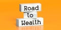 Road to wealth - words on wooden blocks