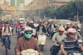 Road traffic crowded with motorbikes and scooter drivers.