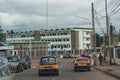 Road traffic, with yellow cabs, motorcycles, other vehicles and people on avenue des banques in Yaounde, Cameroon