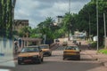 Road traffic, with yellow cabs, motorcycles, other vehicles and people on a street of ngousso in Yaounde, Cameroon