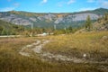 Road, trail in steppe among hills and mountains covered with yellow grass and green trees. Baikal nature. Mountain ranges. Autumn Royalty Free Stock Photo