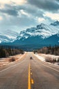 Road trip on highway between pine forest driving straight to rocky mountains in Icefields Parkway