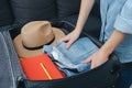 Road trip wanderlust lifestyle concept. Side view of female hands neatly packing and organizing suitcase. Stack clothing for Royalty Free Stock Photo