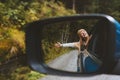 Road trip woman traveling by rental car adventure lifestyle vacation vibes outdoor forest view mirror reflection Royalty Free Stock Photo