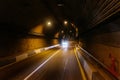 Road tunnel in mountain illuminated by lamps