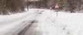 Road turn sign, left. Snowy winter road Royalty Free Stock Photo