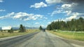 a road with two cars driving down it with hills in the background Royalty Free Stock Photo