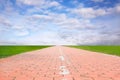 Road under blue sky cloud. Path texture background with green grass and sky. Brick tile path road with copy space Royalty Free Stock Photo