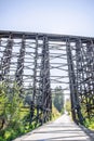 The road through the unique old tall Holcomb creek wooden train trestle wooden railway bridge across the valley Royalty Free Stock Photo