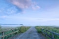 Road via bridge in foggy morning