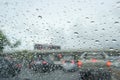 Road view through car window with rain drops driving in rain.