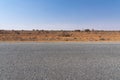 A road view with red dirt at the background and blue sky at outback rural of New South wales, Australia. Royalty Free Stock Photo